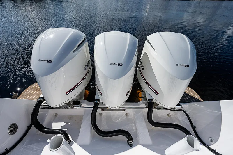 Slide: The Image of Triple outboard engines on a 2016 Intrepid 430 Sport Yacht, docked on calm water. - 44