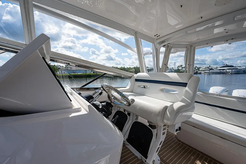 Slide: The Image of Interior view of 2016 Intrepid 430 Sport Yacht helm with luxurious seating and steering wheel. - 47
