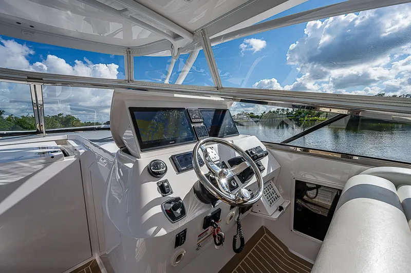 Slide: The Image of 2016 Intrepid 430 Sport Yacht helm with modern controls and scenic water view. - 48