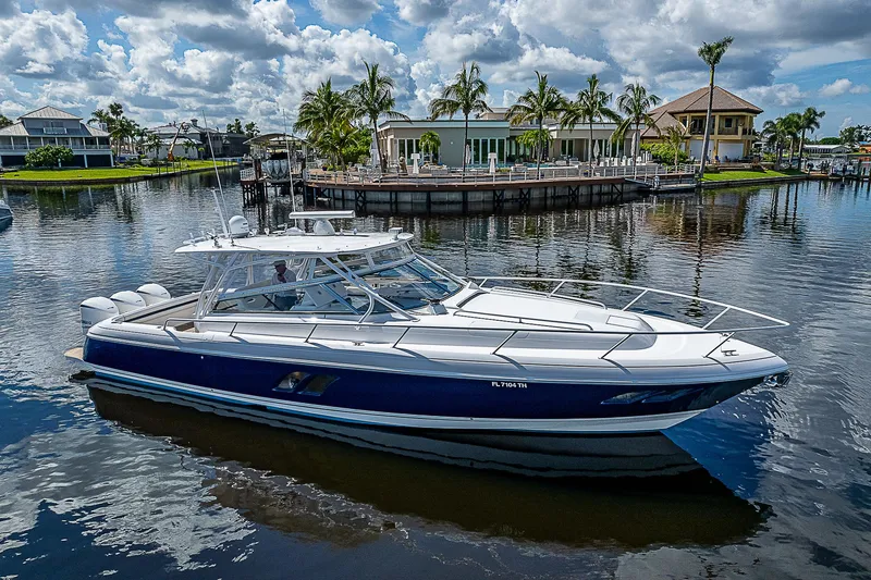 Slide: The Image of 2016 Intrepid 430 Sport Yacht on a scenic waterfront with palm trees. - 9