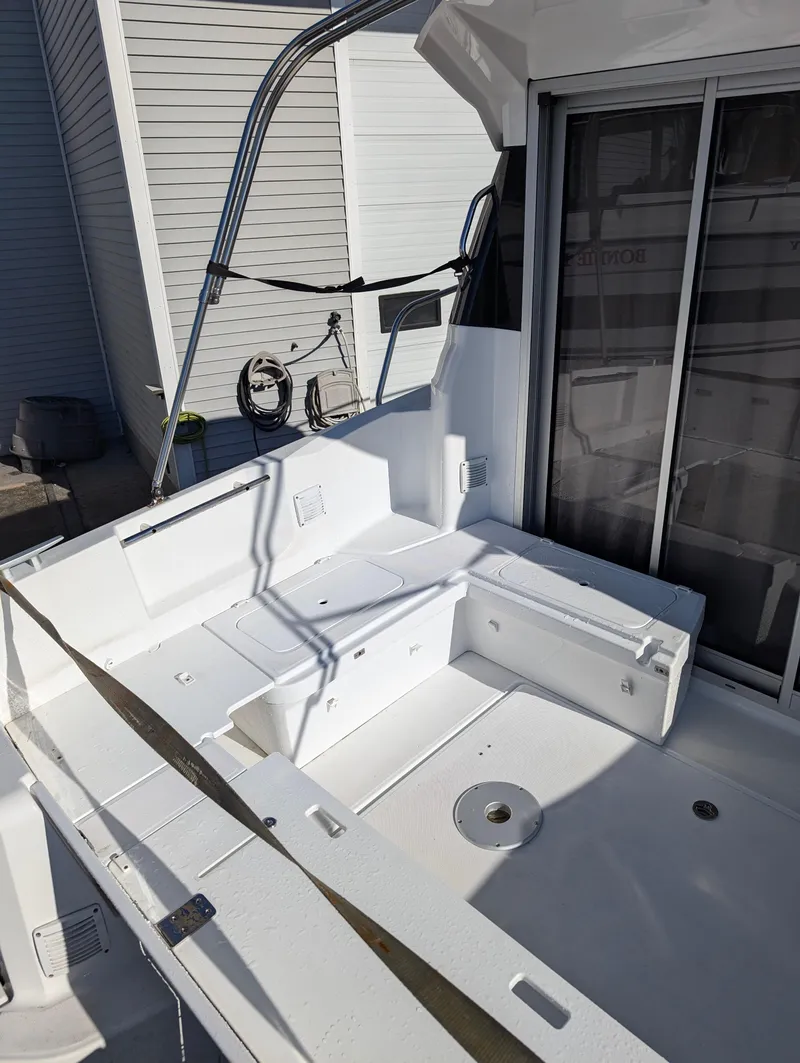 Slide: The Image of 2020 Jeanneau NC 795 boat deck with seating and sliding glass doors. - 18