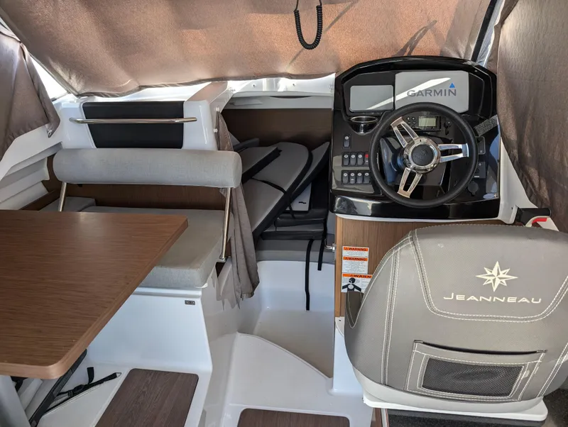 Slide: The Image of Interior of 2020 Jeanneau NC 795 boat with steering wheel and seating area. - 20