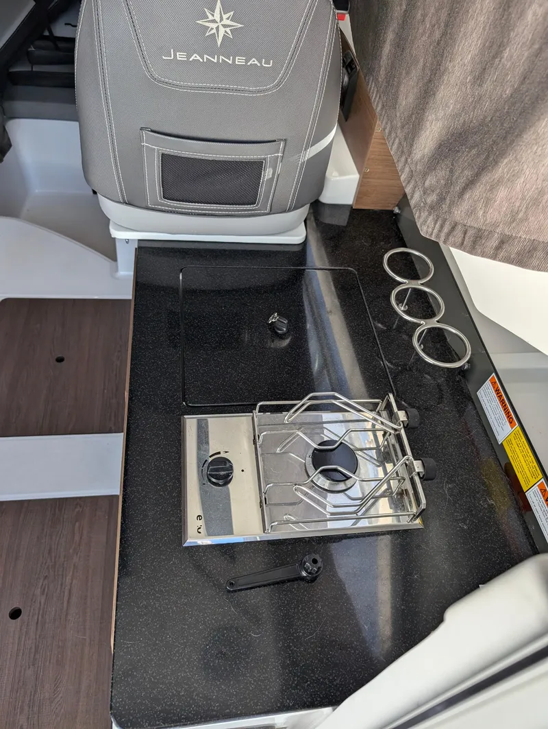 Slide: The Image of 2020 Jeanneau NC 795 boat interior with compact stove and seating. - 21