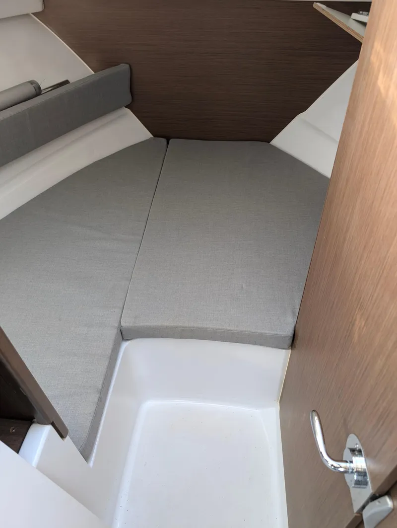 Slide: The Image of 2020 Jeanneau NC 795 cabin interior with gray cushions and wooden accents. - 22