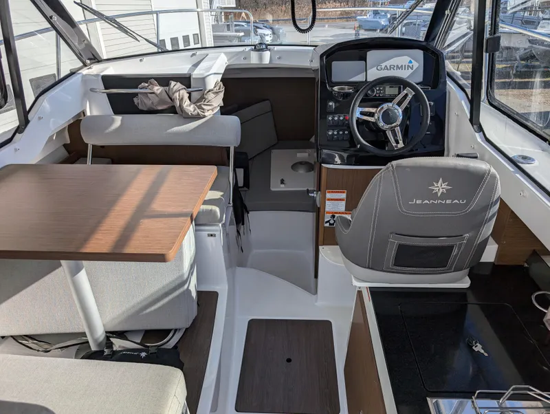 Slide: The Image of Interior of 2020 Jeanneau NC 795 boat with steering wheel and seating area. - 31
