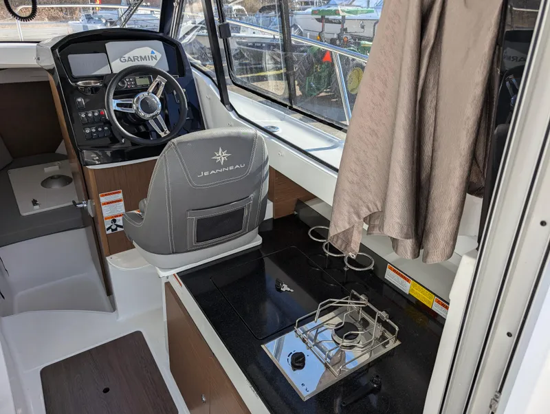 Slide: The Image of 2020 Jeanneau NC 795 interior with steering wheel and compact kitchen area. - 32