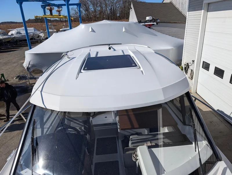 Slide: The Image of 2020 Jeanneau NC 795 boat with sunroof, docked near a storage facility. - 34