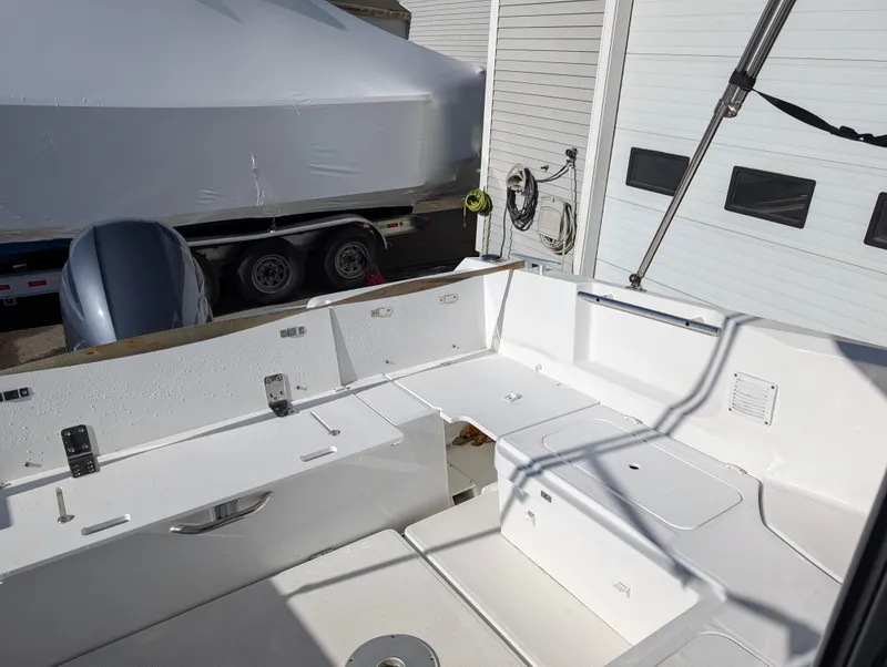 Slide: The Image of 2020 Jeanneau NC 795 boat deck with storage compartments and outboard motor. - 36