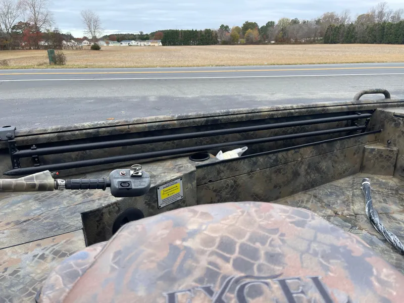 Slide: The Image of 2025 Excel Eclipse boat interior with camouflage design, parked near a rural road. - 13