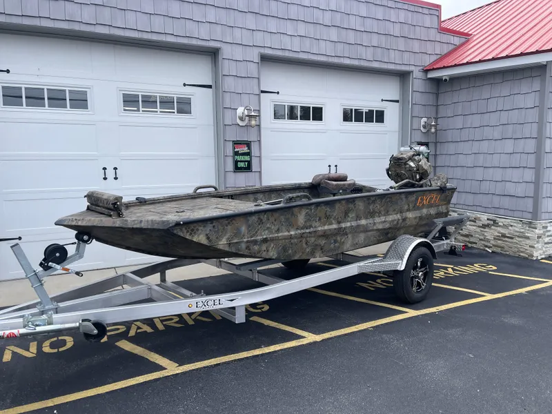 Slide: The Image of 2025 Excel Eclipse boat on trailer, parked outside garage. - 2