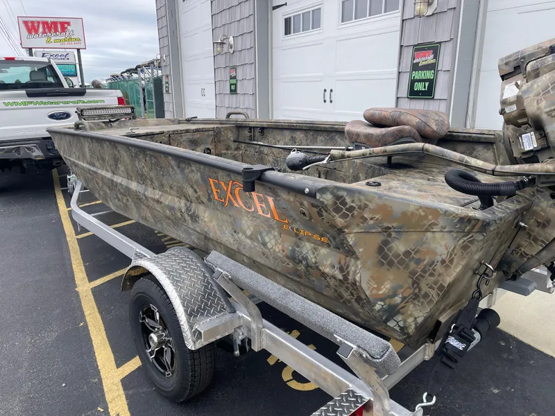 Slide: The Image of Camouflage Excel Eclipse 2025 boat on trailer, parked outside a building. - 6