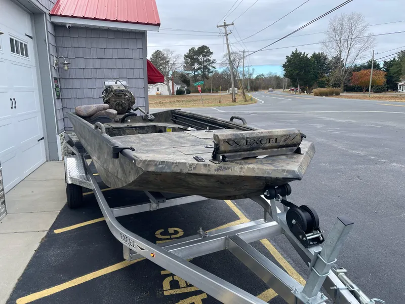 Slide: The Image of 2025 Excel Eclipse boat on trailer, parked near a building with a red roof. - 8