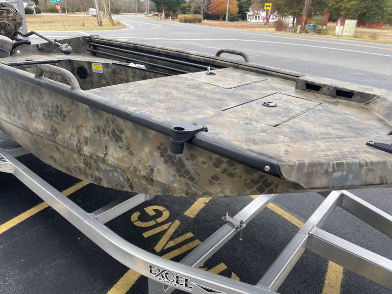 Slide: The Image of 2025 Excel Eclipse boat on trailer, camouflage design, parked near road. - 9