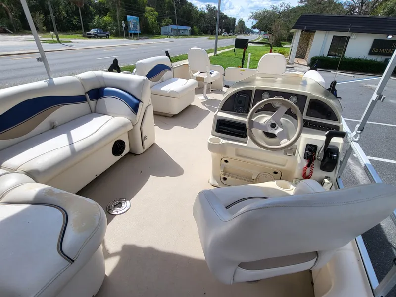 Slide: The Image of 2006 Godfrey Sweetwater 2586DF pontoon boat interior with plush seating and steering console. - 7