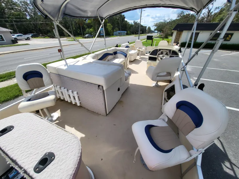 Slide: The Image of 2006 Godfrey Sweetwater 2586DF pontoon boat with spacious seating and canopy in a parking lot. - 8