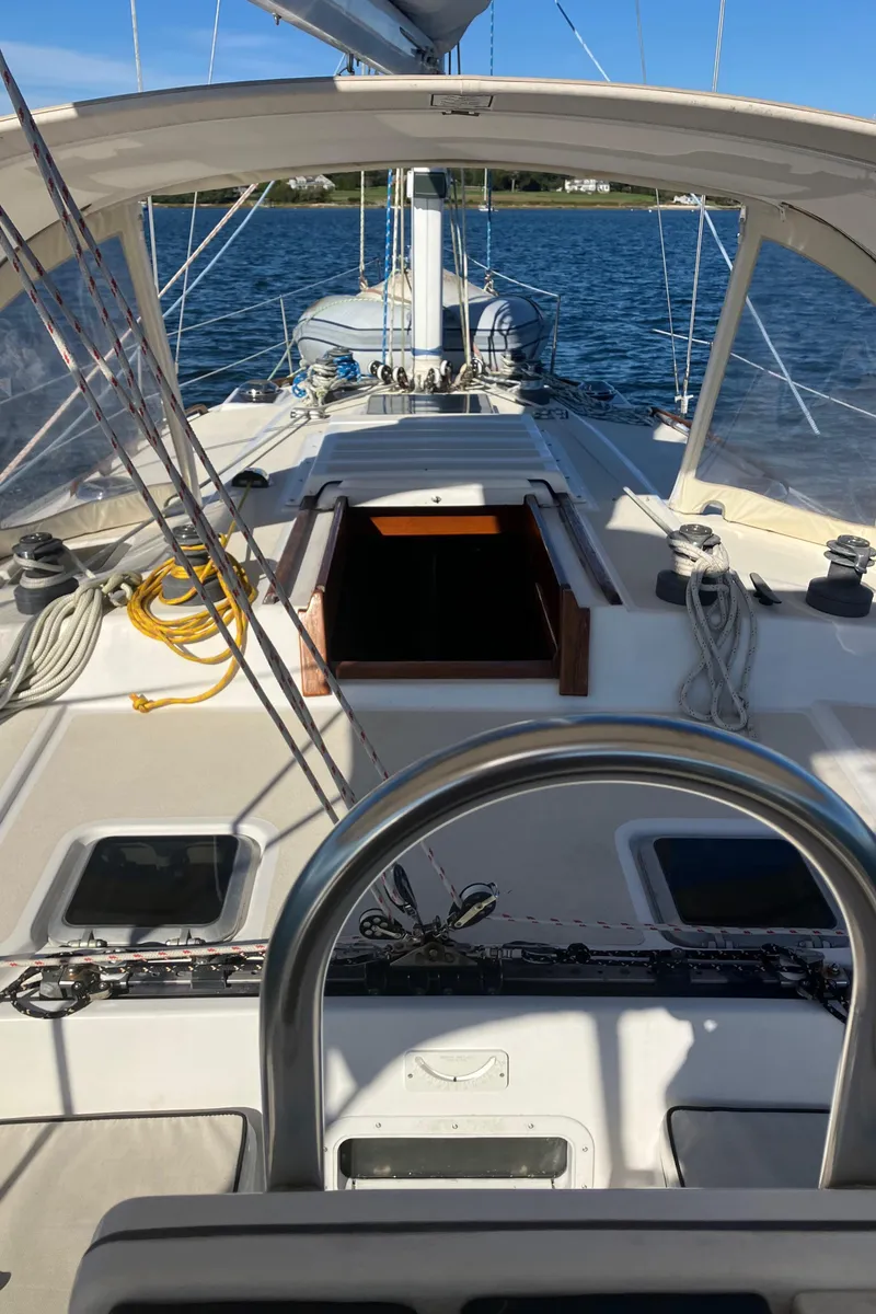 Slide: The Image of 1983 Morgan NELSON MAREK 454 sailboat cockpit with open hatch, ropes, and clear sky. - 4