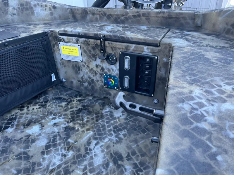 Slide: The Image of 2025 Excel 1860 F4 Shallow Water boat interior with control panel and camo design. - 10