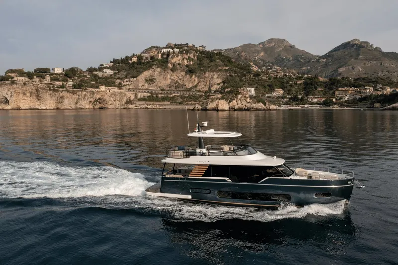 Slide: The Image of 2025 Azimut Magellano 60 yacht cruising near scenic coastal cliffs. - 25