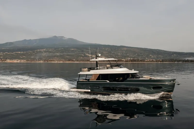 Slide: The Image of 2025 Azimut Magellano 60 yacht cruising on calm waters with scenic mountain backdrop. - 18