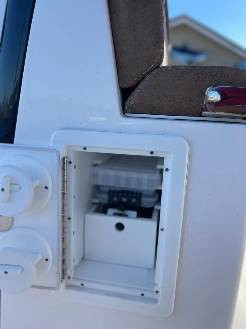 Slide: The Image of 2022 Caymas 341 CC boat compartment with open storage and control panel. - 43