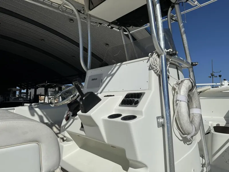 Slide: The Image of 2005 Sailfish 236 CC boat console with steering wheel and life preserver. - 10