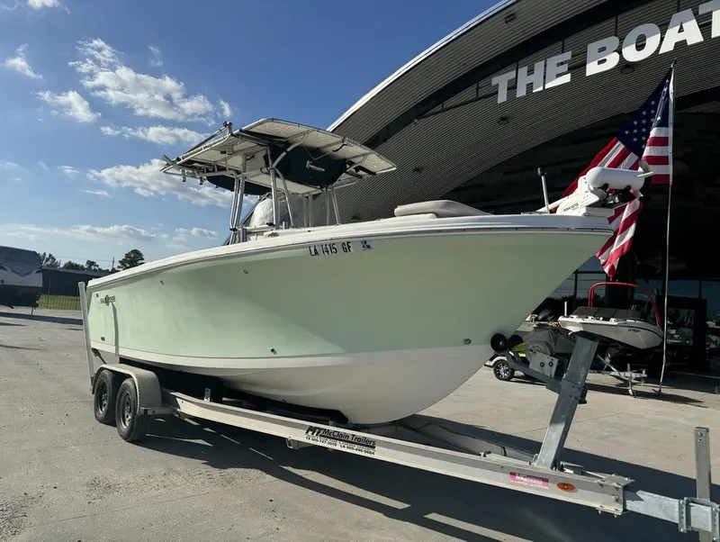 Slide: The Image of 2005 Sailfish 236 CC boat on trailer, parked outside dealership with American flag. - 16