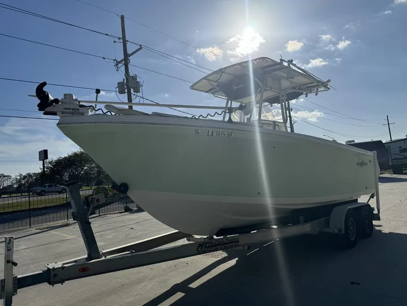 Slide: The Image of 2005 Sailfish 236 CC boat on trailer under sunny sky. - 8