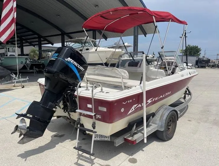 Slide: The Image of 2002 Bay Stealth 1880 BSVW boat with Mercury outboard motor and red canopy. - 3