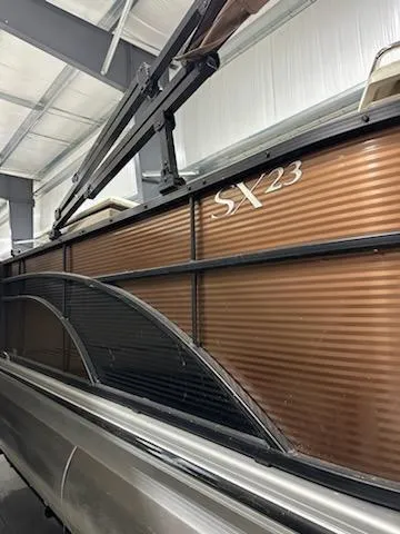 Slide: The Image of 2020 Bennington 23SPDXP pontoon boat in storage, featuring SX23 model marking. - 8