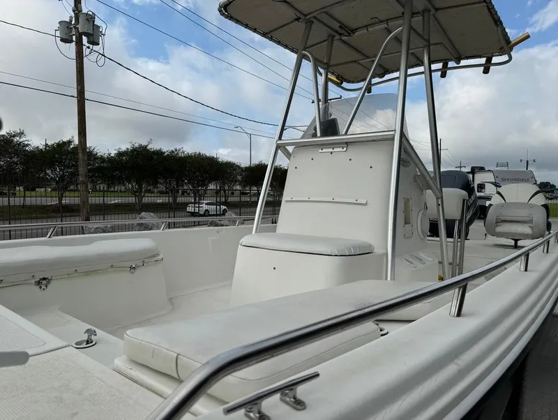 Slide: The Image of 2001 Bay Stealth 2230 boat with spacious seating and T-top, parked outdoors. - 14