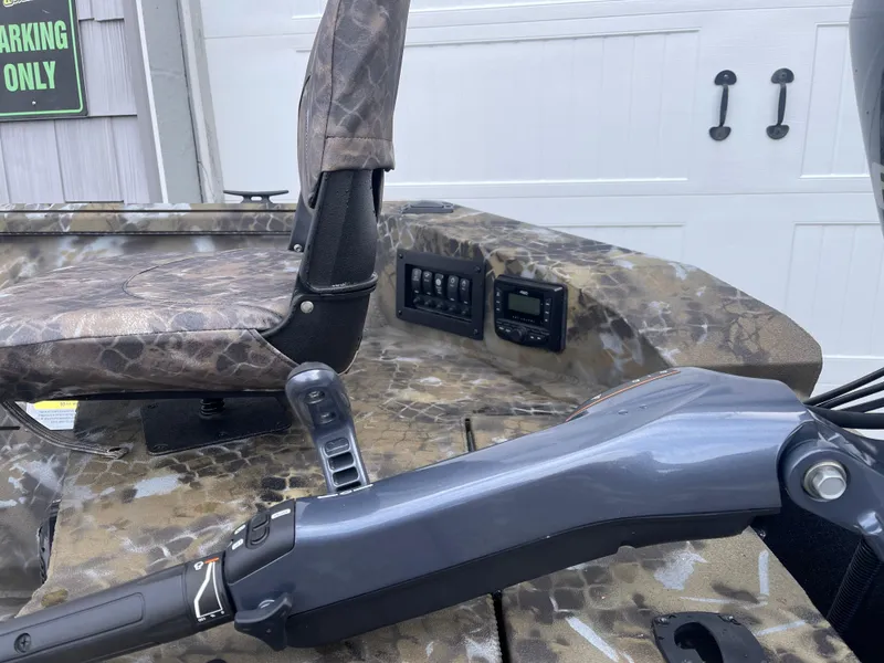 Slide: The Image of 2025 Excel 1751 River Warrior boat interior with camo seat and control panel. - 11