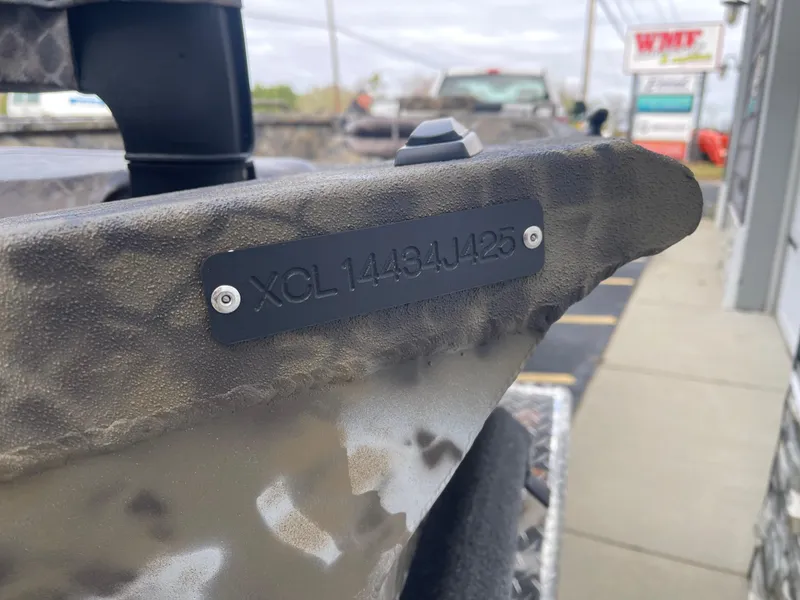 Slide: The Image of 2025 Excel 1751 River Warrior boat with identification plate, parked near a dealership. - 13