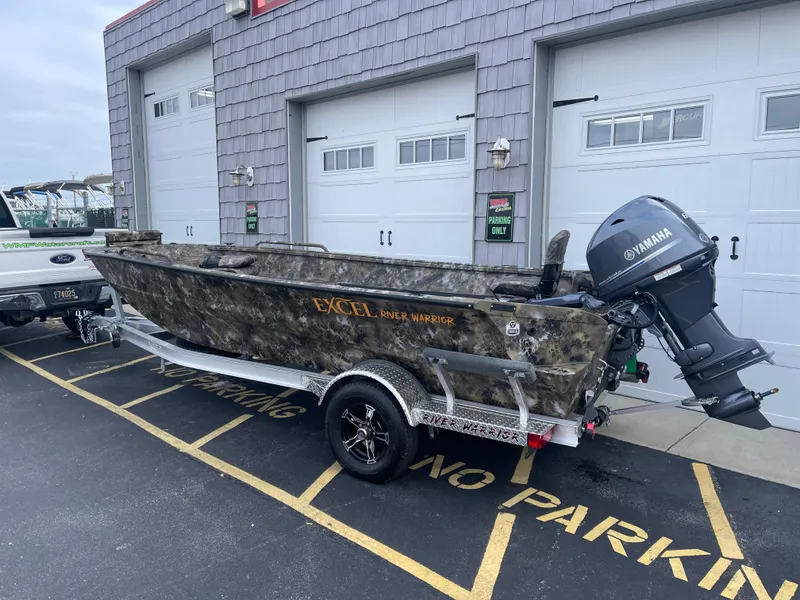 Slide: The Image of 2025 Excel 1751 River Warrior boat with Yamaha motor on trailer, parked outside garage. - 3