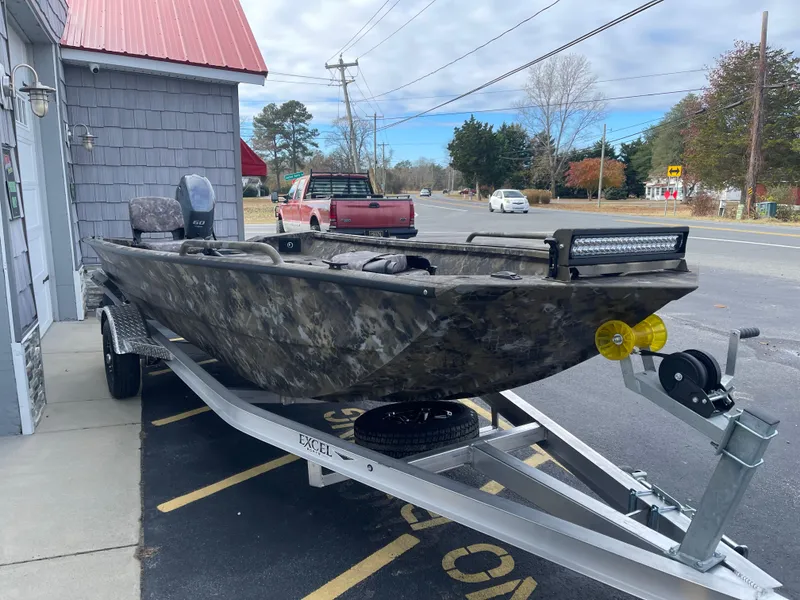 Slide: The Image of 2025 Excel 1751 River Warrior boat on trailer, parked outside a building. - 4