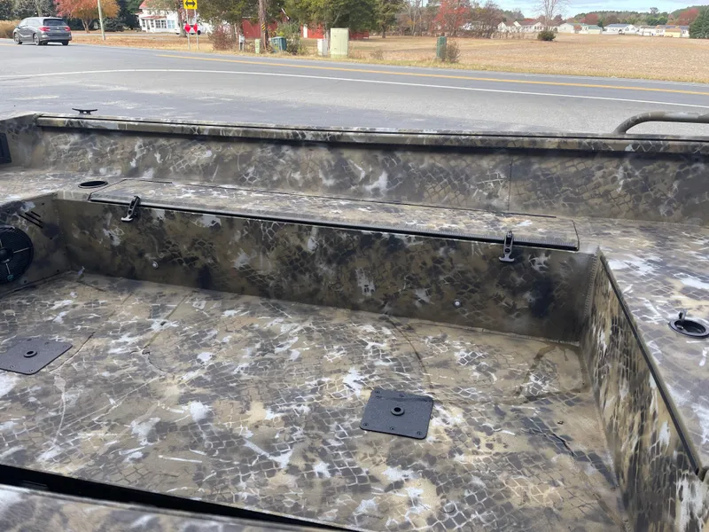 Slide: The Image of 2025 Excel 1751 River Warrior boat interior with camouflage design, parked near a road. - 7