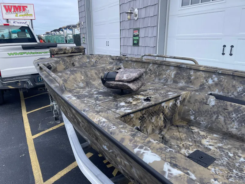 Slide: The Image of 2025 Excel 1751 River Warrior boat with camouflage design parked outside a garage. - 9