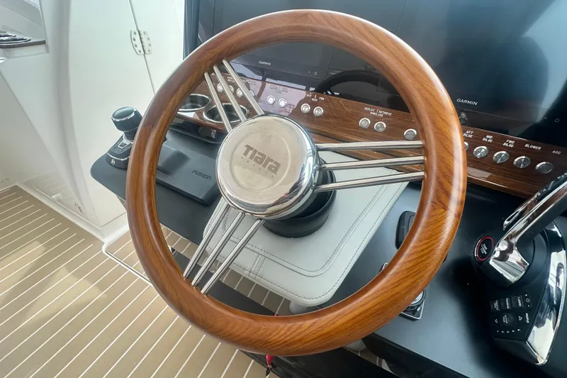 Slide: The Image of Steering wheel of 2026 Tiara Yachts 34 LX, featuring wood and chrome accents. - 10