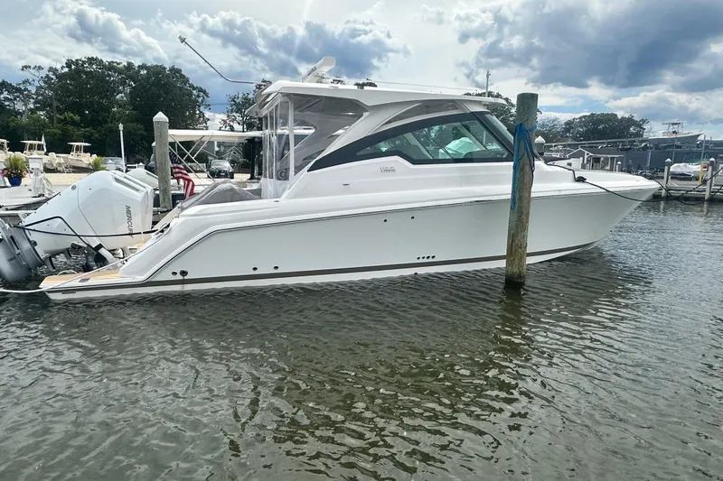 Slide: The Image of 2026 Tiara Yachts 34 LX docked in a marina under cloudy skies. - 21