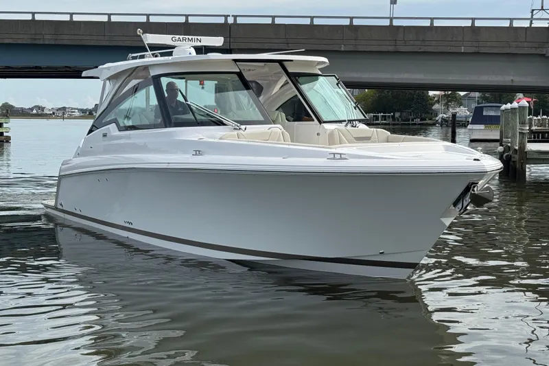 Slide: The Image of 2026 Tiara Yachts 34 LX boat on water near a bridge, showcasing sleek design. - 23