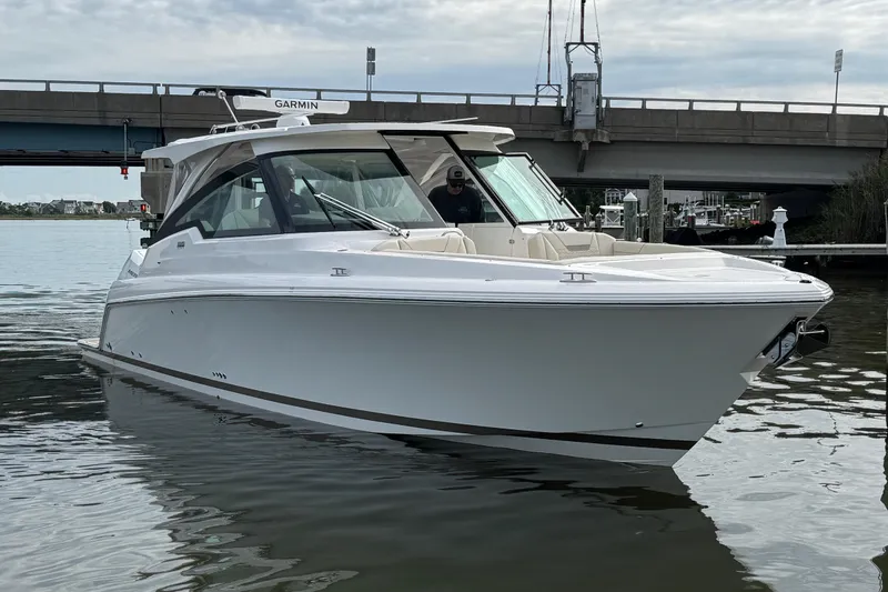 Slide: The Image of 2026 Tiara Yachts 34 LX boat on water near a bridge, showcasing sleek design. - 24