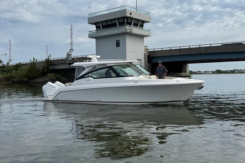 Slide: The Image of 2026 Tiara Yachts 34 LX cruising near a bridge on a calm waterway. - 26