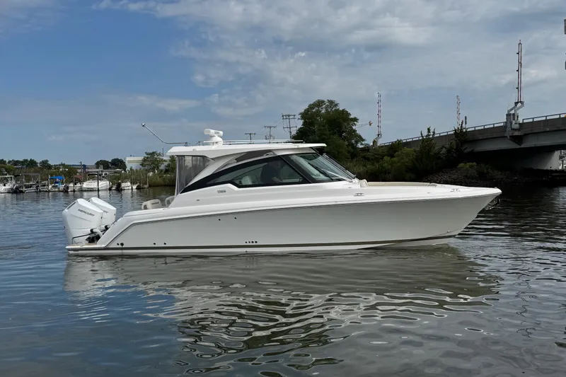 Slide: The Image of 2026 Tiara Yachts 34 LX cruising on calm waters near a bridge. - 27