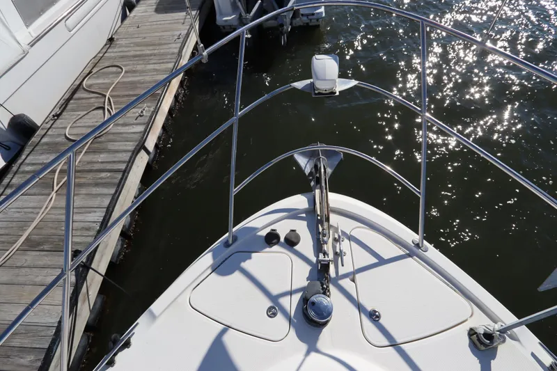 Slide: The Image of Bow view of 2005 Meridian 459 Motoryacht docked, with gleaming water reflections. - 3