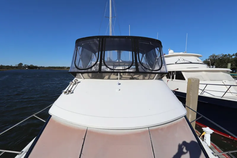 Slide: The Image of 2005 Meridian 459 Motoryacht docked, featuring spacious deck and enclosed flybridge. - 7