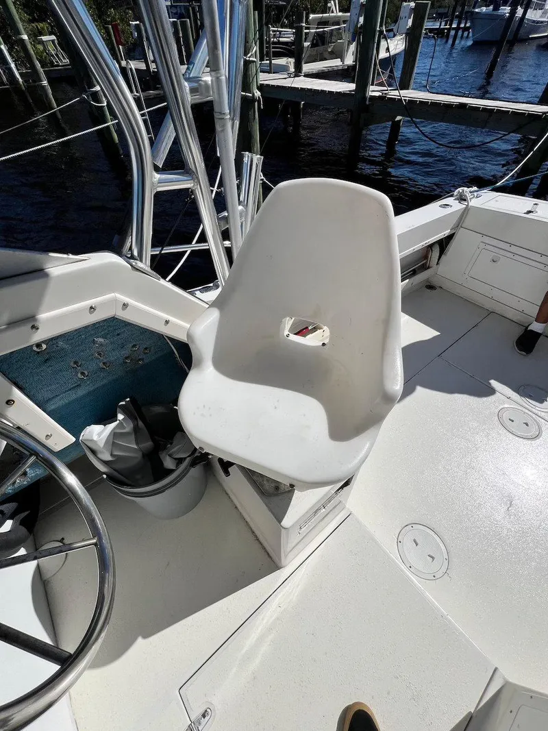 Slide: The Image of 1988 Grady-White 25 Sailfish boat cockpit with white captain's chair and steering wheel. - 17