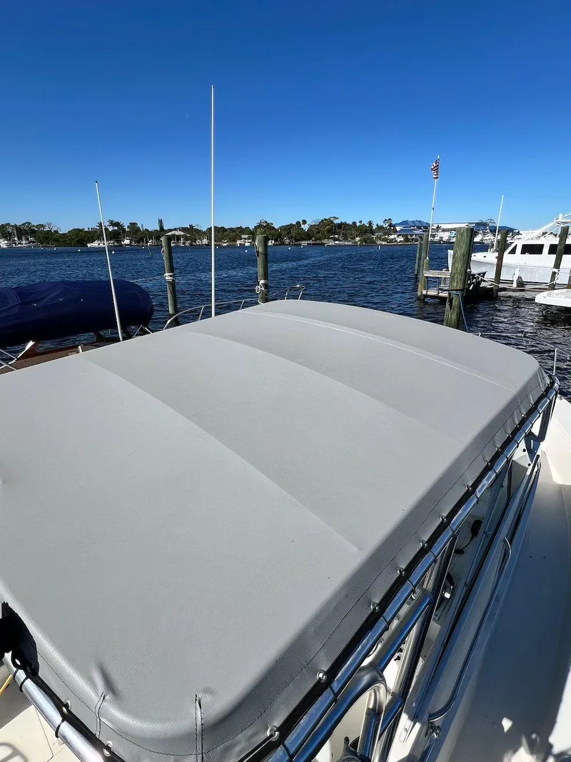 Slide: The Image of 1988 Grady-White 25 SAILFISH boat with covered deck, docked by a scenic waterfront. - 27