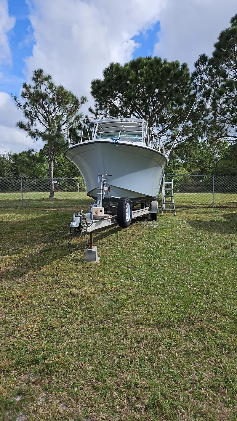Slide: The Image of 1988 Grady-White 25 SAILFISH boat on trailer, parked on grass, surrounded by trees. - 30