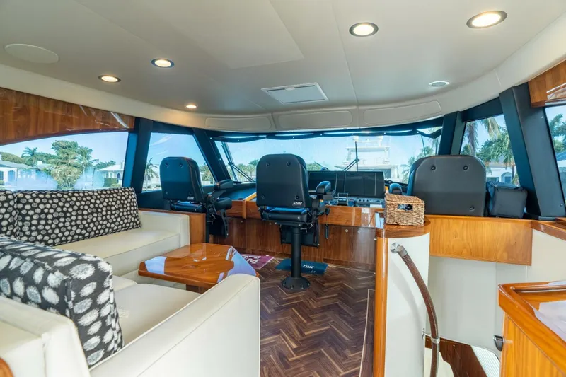 Slide: The Image of Luxurious interior of 2021 Viking 68 Enclosed Bridge Convertible yacht with modern seating and helm. - 19