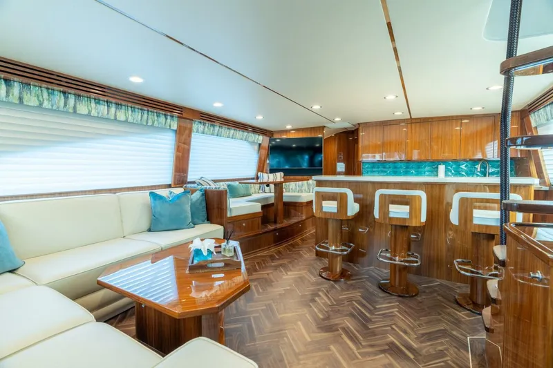 Slide: The Image of Luxurious interior of 2021 Viking 68 Enclosed Bridge Convertible yacht with elegant seating and bar area. - 2