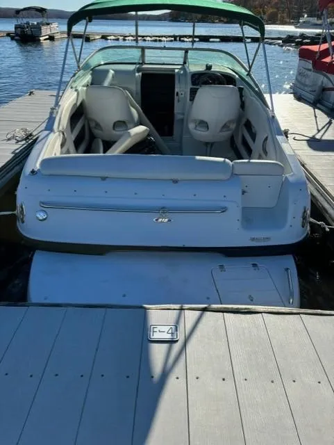 Slide: The Image of 2002 Crownline 215 CCR boat docked at a marina, featuring a green canopy. - 11